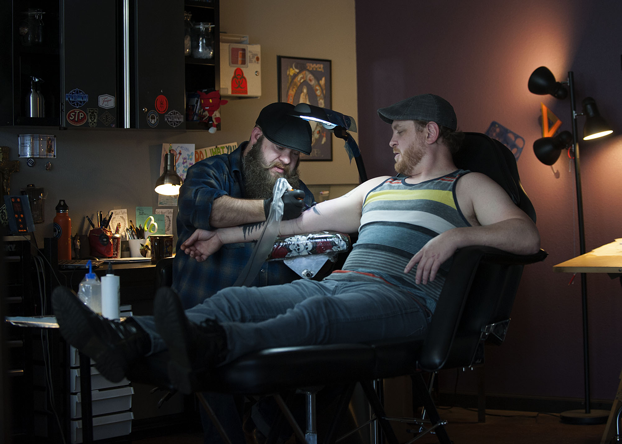 Tattoo artist Ryan "Boomer" Boomhower, left, works with customer Joel Schmid of Camas at 3rd Heart Tattoo on Tuesday afternoon, Oct. 6, 2015 in Washougal. (Amanda Cowan/The Columbian)